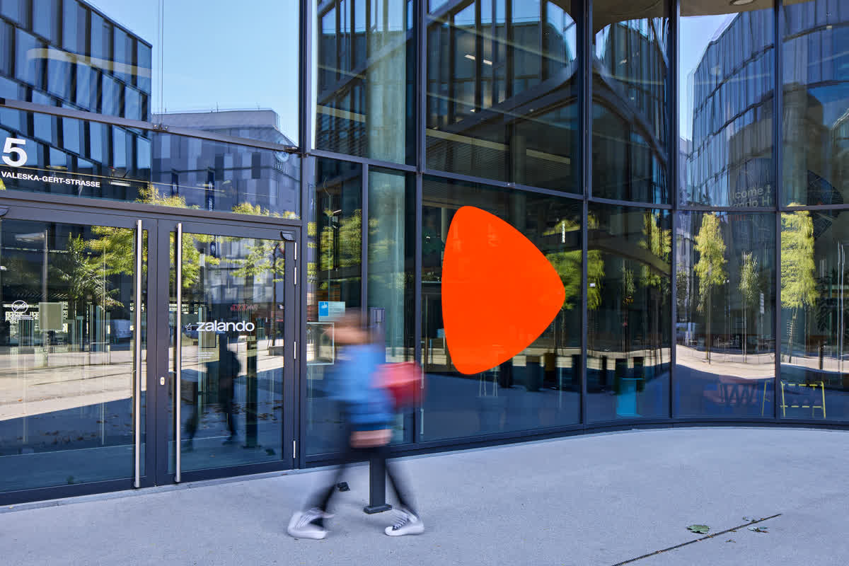 Zalando 공식 홍보 자료의 베를린 본사 — 유리 외벽에 붙은 주황색 Zalando 마크